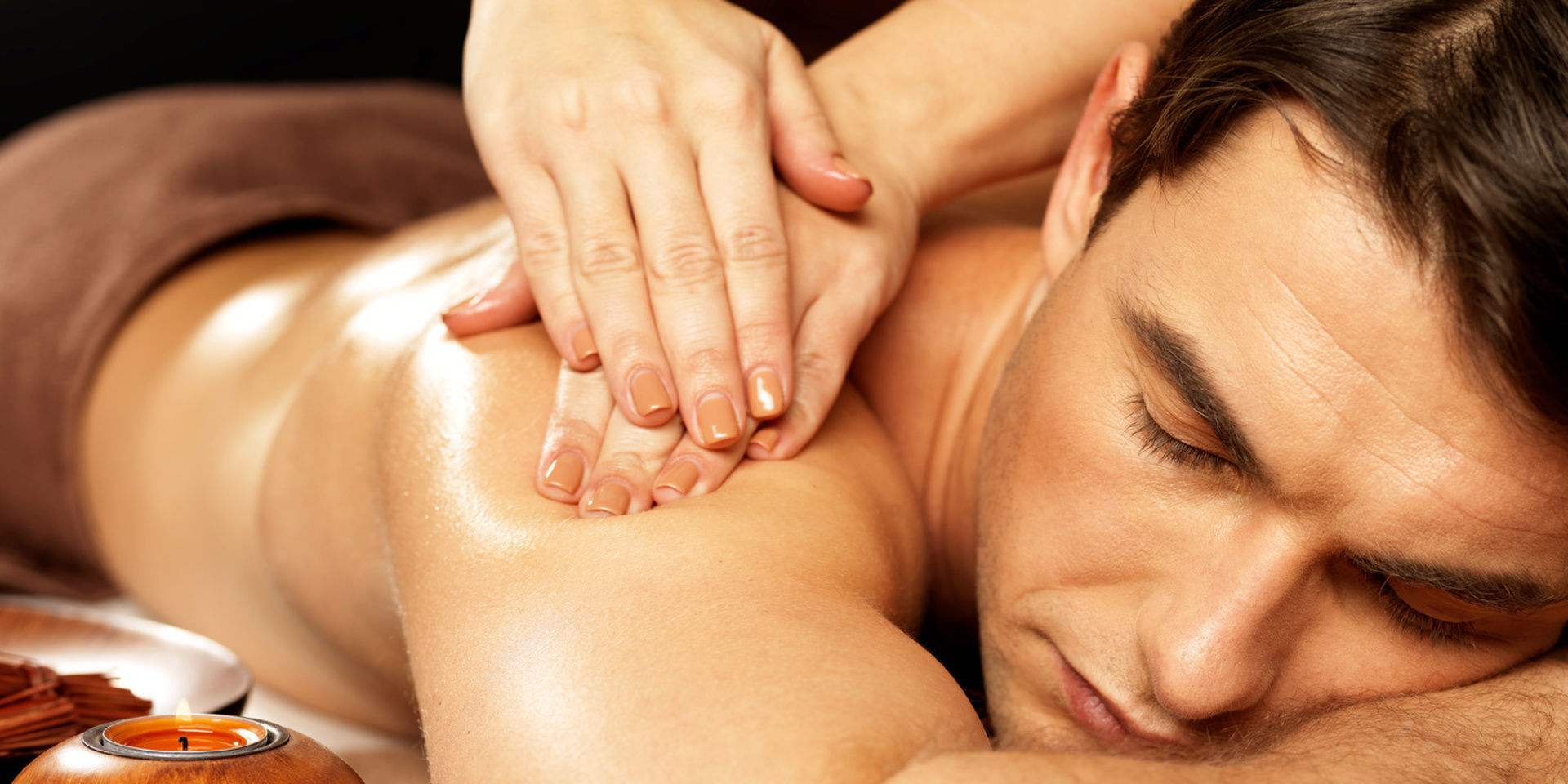 Dame massiert Mann mit Öl auf dem Massagetisch im St. Wolfgang