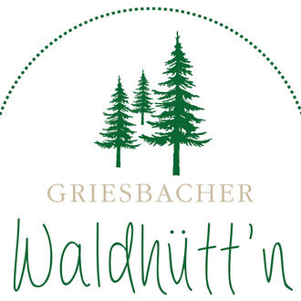 Lächelnde Frau im Grünen, die sitzend nach vorn gebeugt ist.