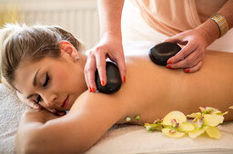 Eine junge Dame erhält eine Hot Stone Massage im St. Wolfgang