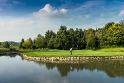 Golfer auf einem von Wasser umgebenen Grün des Golf Resort Bad Griesbach.