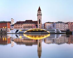 Vom Schiff beleuchtete Flusslandschaft bei der Donauschifffahrt in Passau.